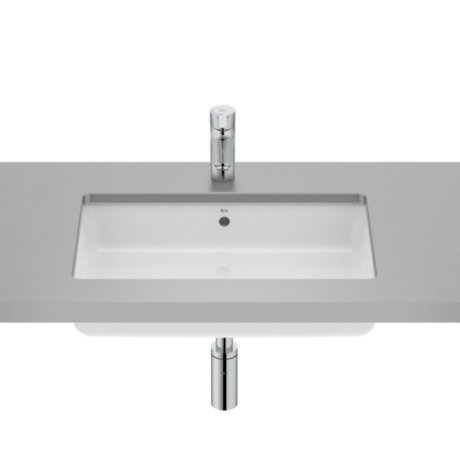 White rectangular undermount sink set into a gray countertop with a chrome single-handle faucet above and a chrome drain visible below (photo with mirrored reflection).