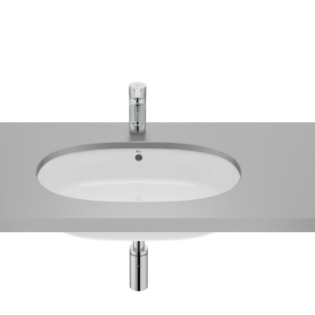 Oval white bathroom sink embedded in a gray countertop with a chrome faucet above and exposed drain pipe below.