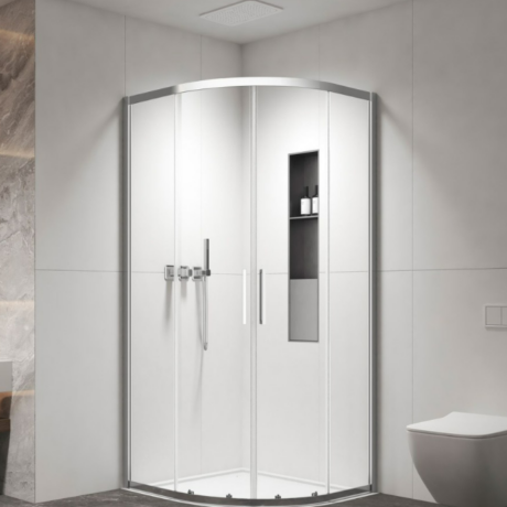 Curved glass shower enclosure with chrome frame in a modern bathroom, built-in niche holding toiletries, next to a wall-hung toilet