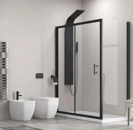 Contemporary bathroom with a glass-framed shower, black fixtures, and a white toilet and bidet; chrome towel warmer on the wall and a chair by a large window in the corner.