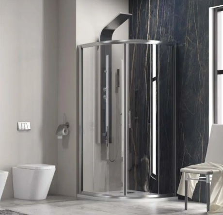 Modern bathroom featuring a curved glass shower enclosure, white toilet and bidet, dark marble accent wall, window, and a stool with a towel on it.
