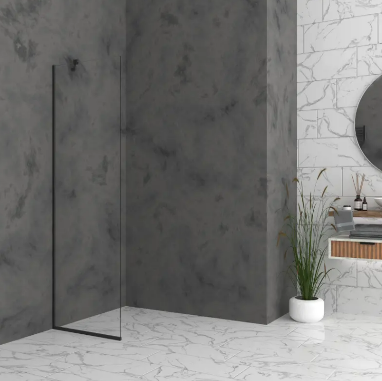 Modern bathroom with a glass-framed shower, dark gray walls, and a white marble floor; round mirror and plant by the sink.