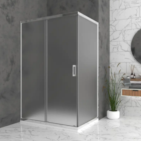 Glass shower enclosure with metal frame and handle in a marble-tiled bathroom, next to a potted plant and round mirror.