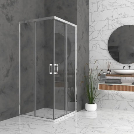 Modern bathroom with a glass shower enclosure, marble walls and floor, a circular mirror above a floating vanity, and a potted plant nearby.