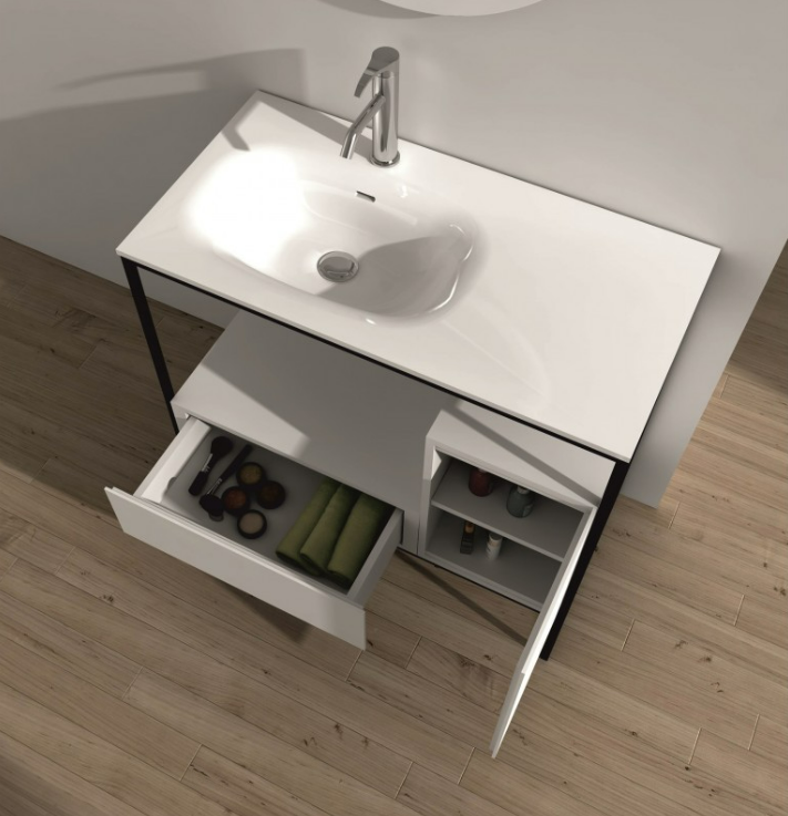 Екранна снимка 2026-08-04 075612 - Мебели за баня и душкабини White bathroom vanity with sink and open drawers showing towels and toiletries on a wooden floor.