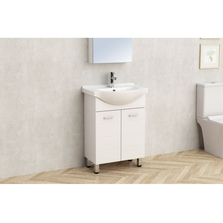 Екранна снимка 2026-08-04 081258 - Мебели за баня и душкабини White bathroom vanity with curved sink and chrome faucet, two top drawers and two bottom doors, beside a toilet on a light tiled wall and chevron wood floor.
