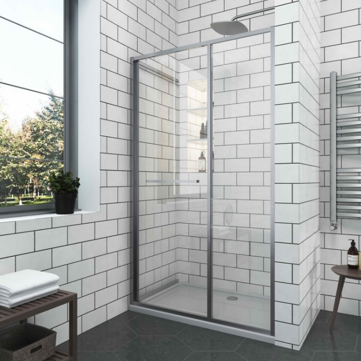 Екранна снимка 2026-08-04 144623 - Мебели за баня и душкабини Glass-framed shower enclosure with sliding doors in a modern bathroom, white subway-tiled walls, and a rainfall showerhead near a windowled wall.