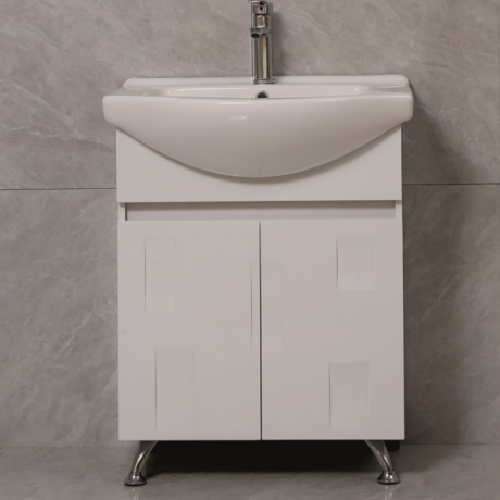 White bathroom vanity with a curved sink and chrome faucet on a gray tiled wall.