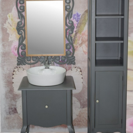 Gray bathroom vanity with a white vessel sink, ornate framed mirror, and a tall matching storage cabinet against a floral backdrop.
