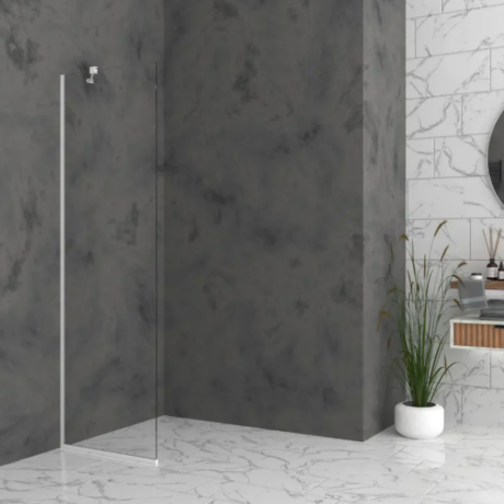 Modern bathroom interior with a glass shower door, dark grey walls, and white marble floor; a potted plant sits near a marble-tile vanity with a round mirror.