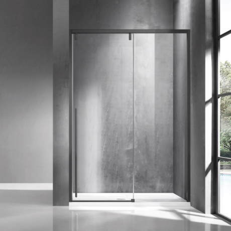 Modern glass shower enclosure with a metal frame in an industrial concrete bathroom with a large window on the right side.